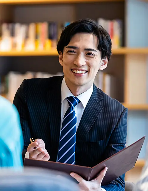 明るい雰囲気で手元の資料を元に会話している若手社員