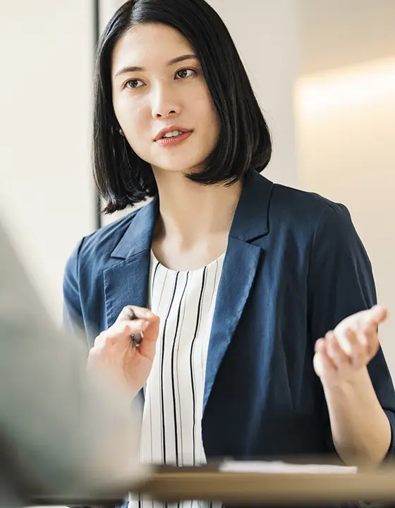 真剣な表情で話すスーツ姿の女性社員