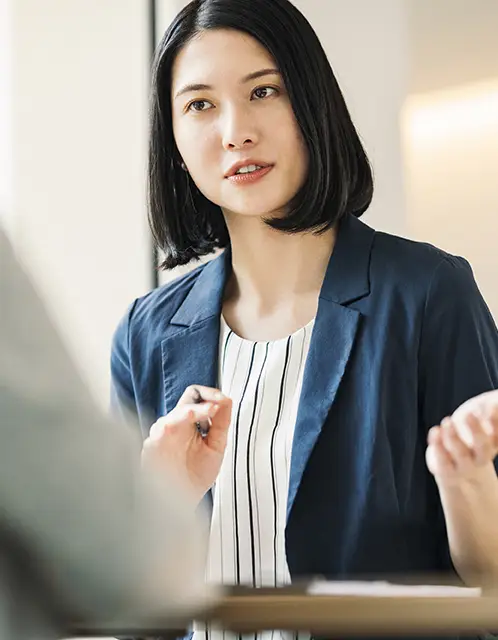 真剣な表情で話すスーツ姿の女性社員