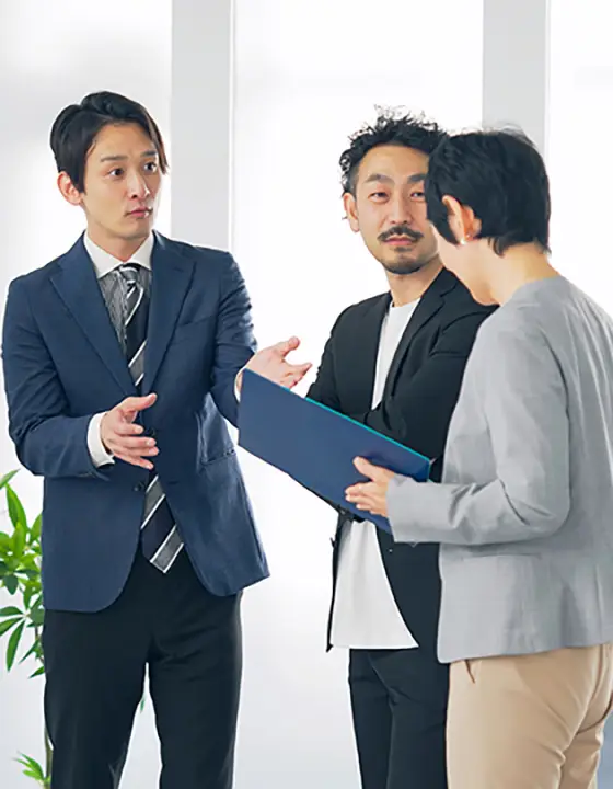 手元の資料を見ながら打ち合わせている社員
