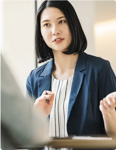 真剣な表情で話すスーツ姿の女性社員