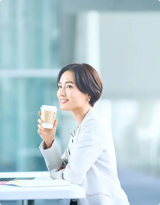 コーヒーを飲みながら仕事をしている女性社員