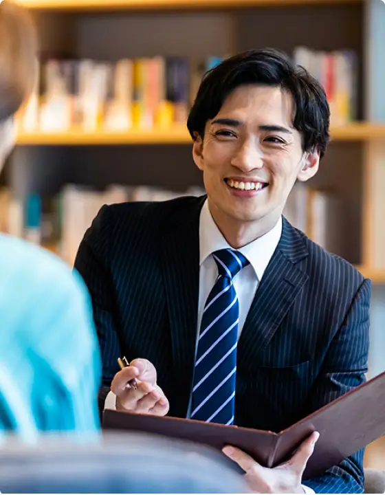 明るい雰囲気で手元の資料を元に会話している若手社員